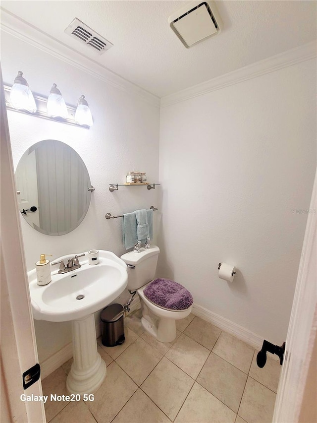 bathroom featuring sink, crown molding, toilet, and tile floors