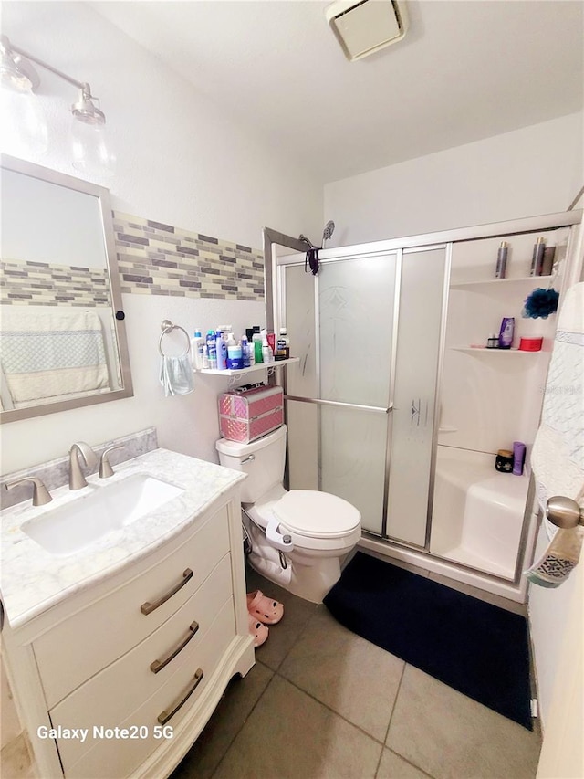 bathroom with an enclosed shower, vanity, toilet, and tile flooring