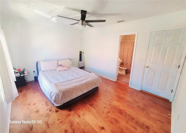 bedroom featuring ceiling fan, hardwood / wood-style flooring, and connected bathroom