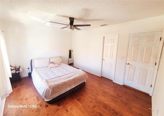 bedroom featuring dark hardwood / wood-style flooring, ceiling fan, and a textured ceiling