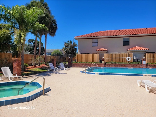 view of pool with a patio and a community hot tub