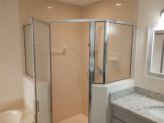 bathroom with vanity and shower with separate bathtub