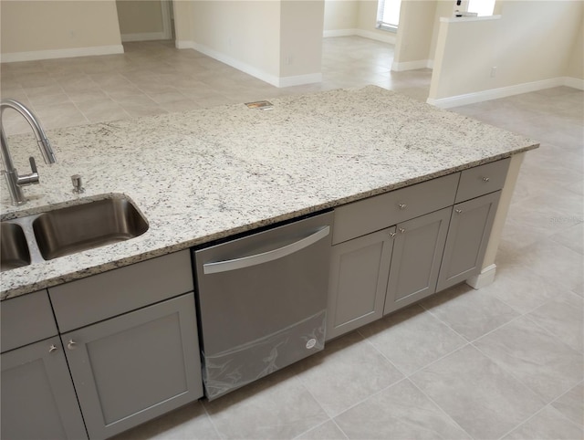 kitchen with light tile flooring, dishwasher, sink, and light stone counters