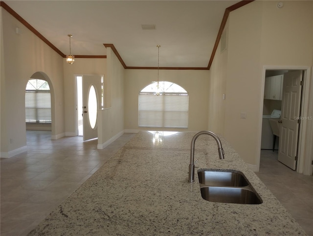 kitchen featuring pendant lighting, tile floors, sink, and light stone countertops