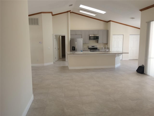 kitchen featuring appliances with stainless steel finishes, a kitchen island with sink, high vaulted ceiling, and light tile floors