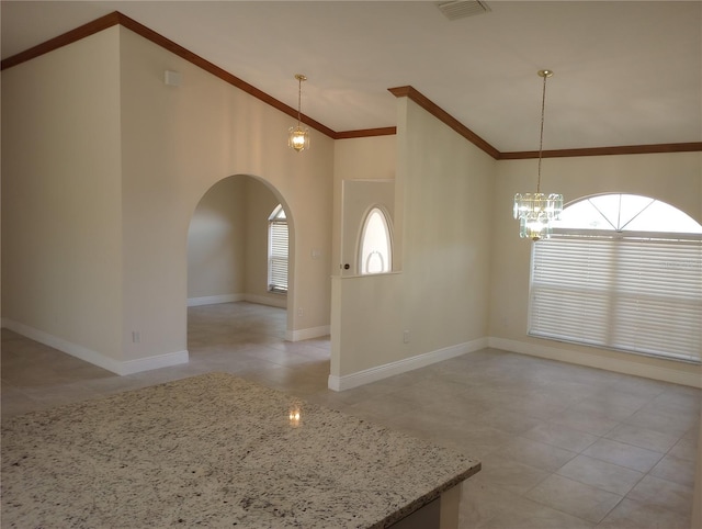 tiled empty room with vaulted ceiling, a notable chandelier, and ornamental molding