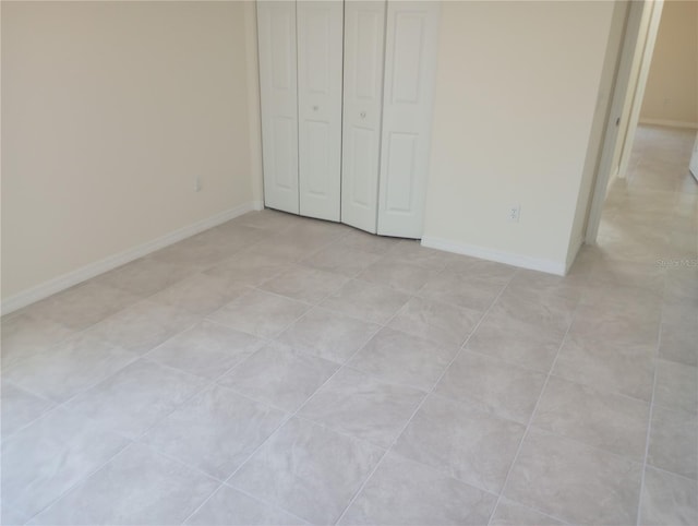 unfurnished bedroom featuring a closet and light tile floors