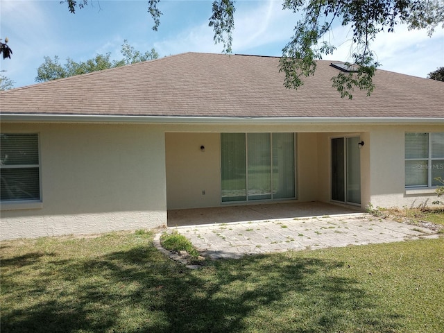 back of house featuring a patio area and a lawn