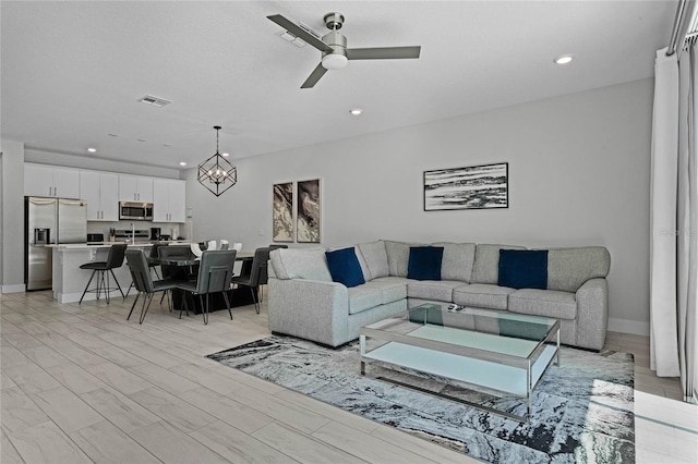 living room with ceiling fan and light wood-type flooring