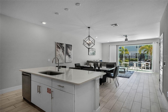 kitchen with ceiling fan, white cabinets, sink, dishwasher, and pendant lighting