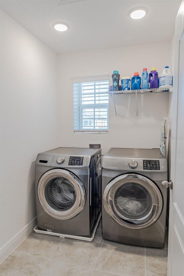 laundry area with hookup for a washing machine, separate washer and dryer, and light tile floors