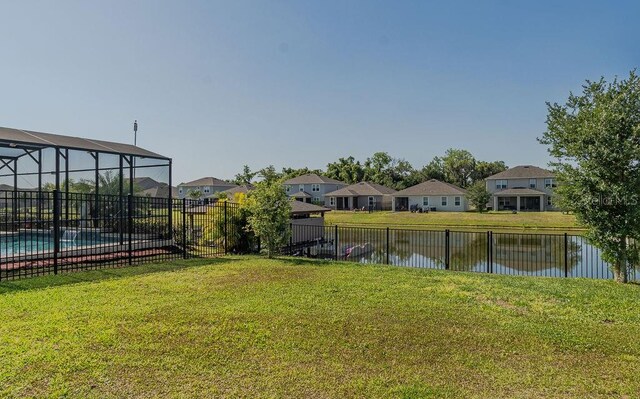 view of yard with a water view and a fenced in pool