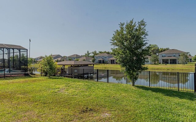 exterior space featuring a deck with water view and a lawn