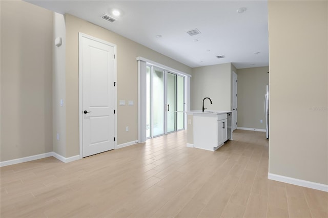 empty room with sink and light hardwood / wood-style floors