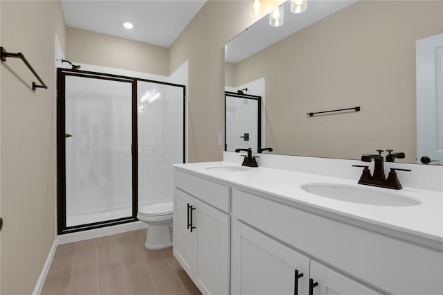 bathroom with vanity, toilet, and a shower with shower door