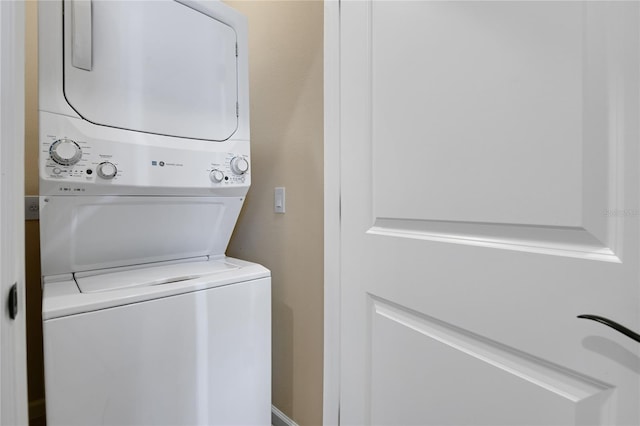 washroom featuring stacked washer / drying machine