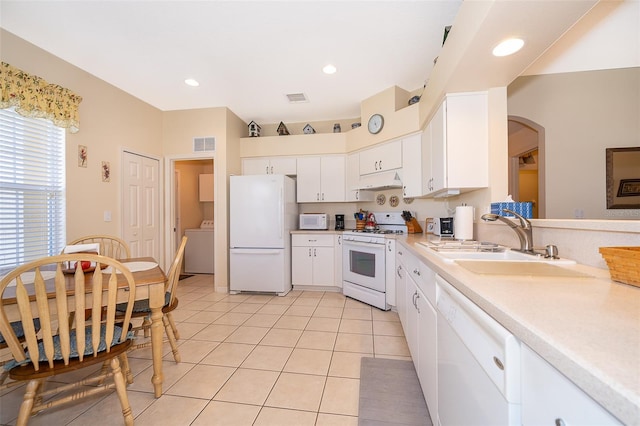 kitchen with white cabinets, sink, white appliances, light tile flooring, and washer / clothes dryer