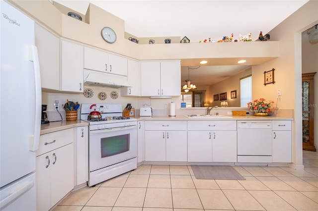 kitchen featuring light tile floors, white cabinets, sink, white appliances, and a notable chandelier