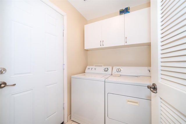 laundry room with cabinets and washing machine and clothes dryer