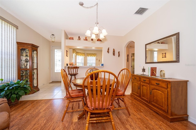 dining room with light hardwood / wood-style floors and a notable chandelier