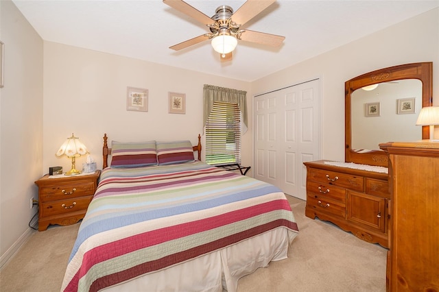 bedroom with light colored carpet, ceiling fan, and a closet