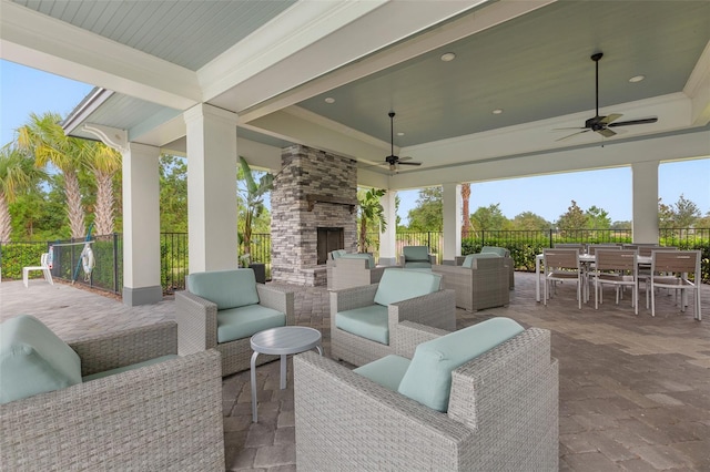 view of patio / terrace featuring ceiling fan and an outdoor living space with a fireplace