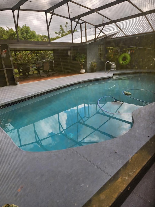 view of pool with a patio and glass enclosure