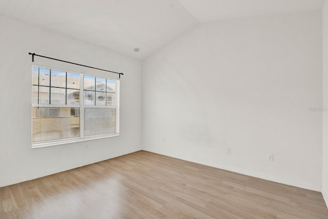 empty room featuring lofted ceiling and light wood-type flooring