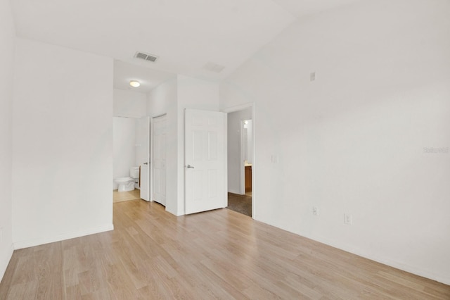 empty room featuring high vaulted ceiling and light wood-type flooring