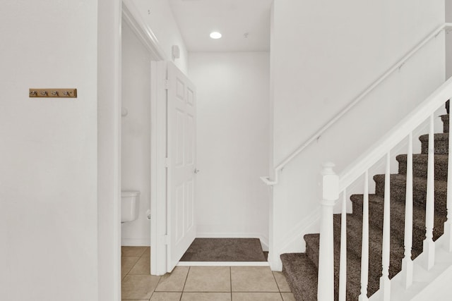 staircase featuring light tile flooring