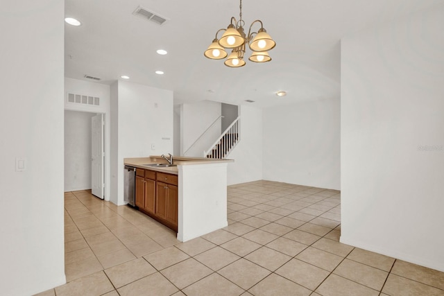 kitchen with stainless steel dishwasher, sink, light tile floors, and pendant lighting