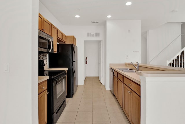 kitchen featuring sink, light tile floors, and black appliances