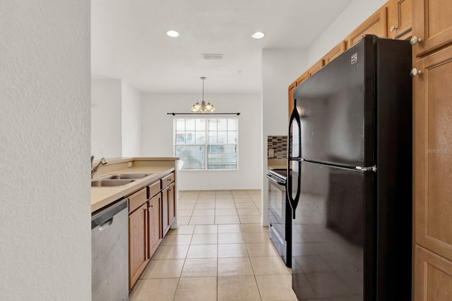 kitchen featuring light tile floors, sink, black appliances, pendant lighting, and an inviting chandelier