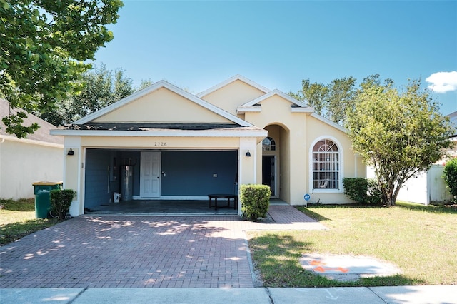2726 Randal Way, Kissimmee, FL 34743 - view of front of property with a garage, decorative driveway, a front lawn, stucco siding, and water heater
