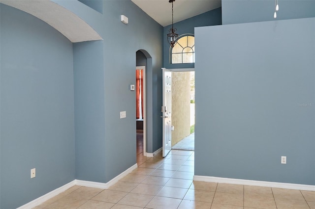 2726 Randal Way, Kissimmee, FL 34743 - unfurnished room featuring arched walkways, light tile patterned floors, baseboards, high vaulted ceiling, and a chandelier