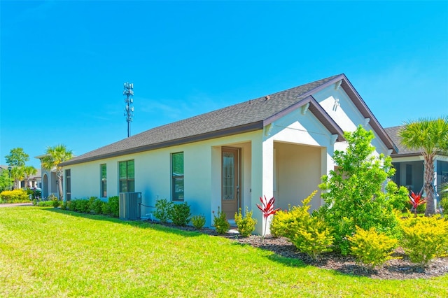 view of front of house with central AC unit and a front yard