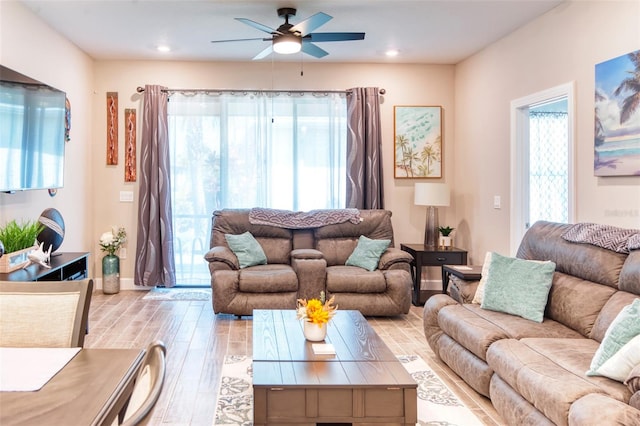 living room with a healthy amount of sunlight, ceiling fan, and light wood-type flooring