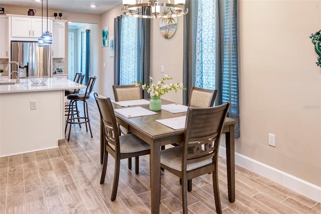 dining space with sink and an inviting chandelier