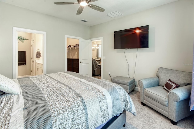 carpeted bedroom featuring a closet, connected bathroom, ceiling fan, and a walk in closet