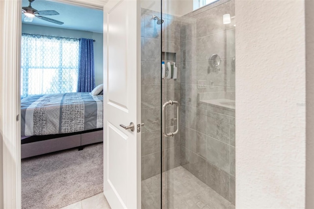 bathroom featuring ceiling fan, a healthy amount of sunlight, and a shower with shower door