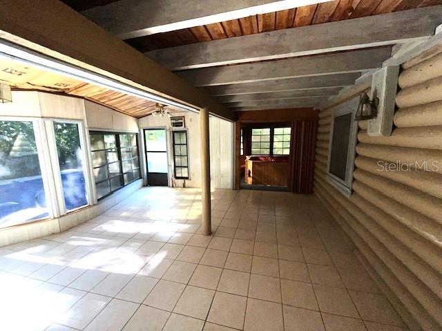 basement featuring plenty of natural light, light tile floors, and wood ceiling