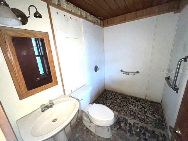 bathroom with tile flooring, sink, wood ceiling, toilet, and a shower