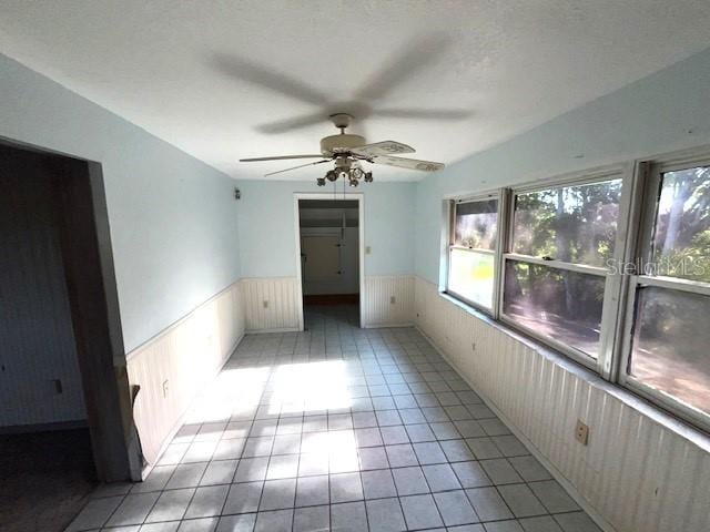 unfurnished room featuring ceiling fan and light tile floors