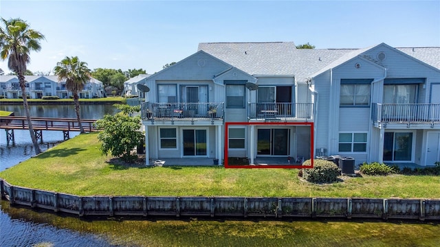 rear view of house featuring a water view, a balcony, central air condition unit, and a lawn