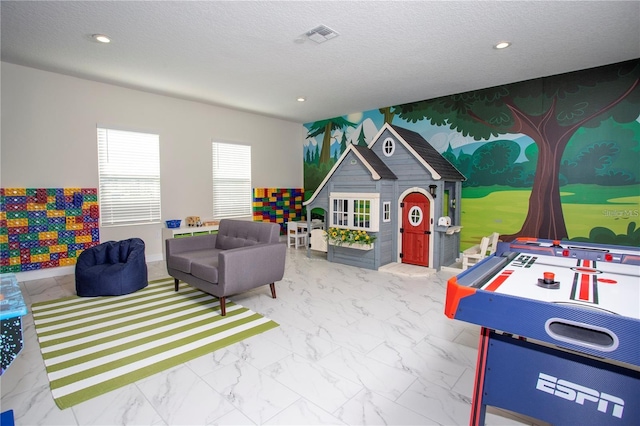 game room with tile flooring and a textured ceiling