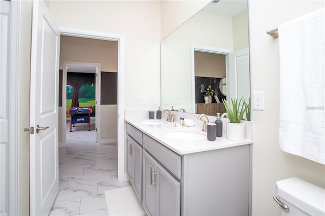 bathroom featuring tile flooring, vanity, and toilet