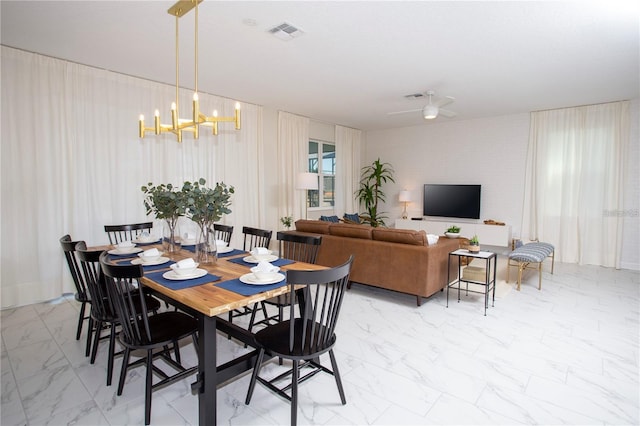 tiled dining space with ceiling fan with notable chandelier