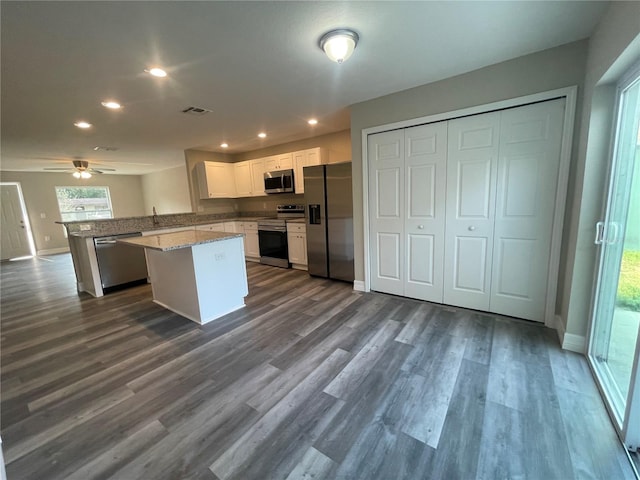 kitchen with dark hardwood / wood-style flooring, ceiling fan, kitchen peninsula, and stainless steel appliances