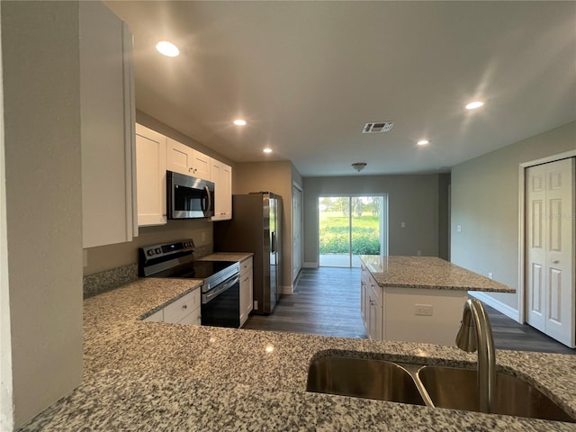 kitchen featuring a kitchen island, white cabinets, sink, dark wood-type flooring, and stainless steel appliances