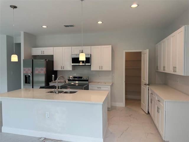 kitchen featuring tasteful backsplash, appliances with stainless steel finishes, sink, and an island with sink